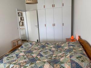 1 dormitorio con 1 cama y armarios blancos en The Flip-Flop Apartment en Shëngjin