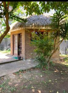a small brick building with a straw roof at Cabañas Hua'ai Village in Hanga Roa