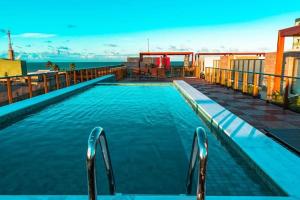 a large swimming pool with a view of the ocean at Ecotambaú, Espetacular Flat Com Piscina ao Lado da Praia in João Pessoa