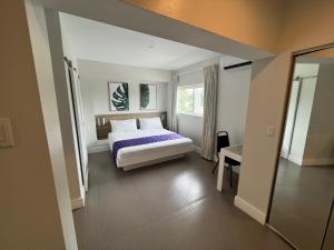een slaapkamer met een bed, een raam en een spiegel bij The Biscayne Hotel in Miami