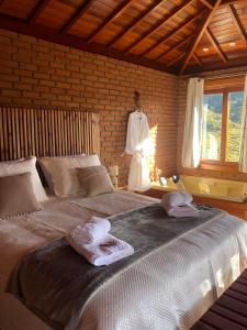 ein Schlafzimmer mit einem großen Bett mit Handtüchern darauf in der Unterkunft Recanto João de barro in Visconde De Maua