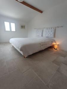 a bedroom with a large bed in a white room at Maison de charme proche Bastia in Prunelli-di-Casacconi