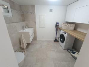 a bathroom with a sink and a washing machine at Maison de charme proche Bastia in Prunelli-di-Casacconi +24 photos