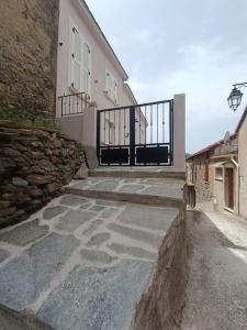 un bâtiment avec un portail et une passerelle en pierre dans l'établissement Maison de charme proche Bastia, à Prunelli-di-Casacconi