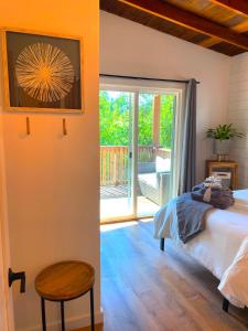 um quarto com uma cama e uma porta de vidro deslizante em Private Wine Country-River Bungalow! Sunny Treetop Views - Pets Stay Free em Forestville