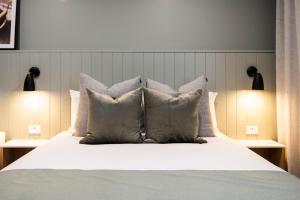 a bedroom with a large bed with pillows at Aden Hotel Mudgee in Mudgee