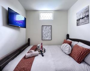 een slaapkamer met een bed en een tv aan de muur bij Cheerful 3Bed Spacious Holiday Home in Abercynon