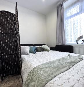 sypialnia z dużym łóżkiem i dużym oknem w obiekcie Cheerful 3Bed Spacious Holiday Home w mieście Abercynon