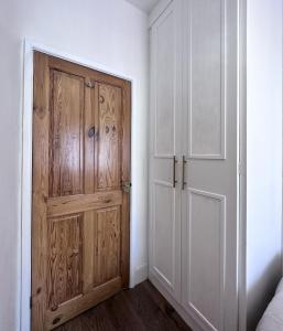 pusty pokój z drewnianymi drzwiami i sypialnią w obiekcie Cheerful 3Bed Spacious Holiday Home w mieście Abercynon