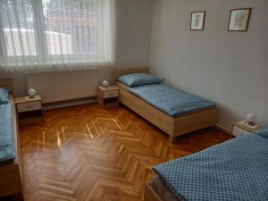 a room with two beds and a wooden floor at Ubytování Na Kopci in Uherské Hradiště