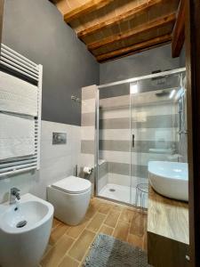 a bathroom with a toilet and a sink and a shower at Locanda In Piazzetta - Casa in Centro Storico in San Quirico dʼOrcia