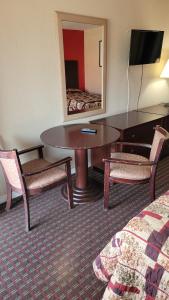 a hotel room with a table and chairs and a mirror at Western Motel in Magee