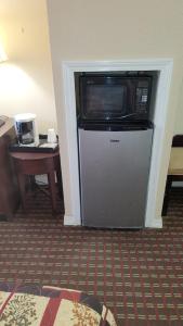 a microwave on top of a refrigerator in a hotel room at Western Motel in Magee