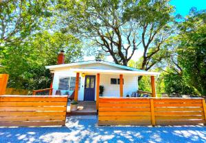 uma pequena casa branca com uma cerca de madeira em Private Wine Country-River Bungalow! Sunny Treetop Views - Pets Stay Free em Forestville