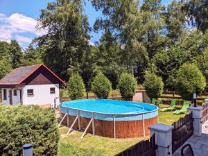 ein Pool in einem Garten mit einem Zaun in der Unterkunft Penzion Mezi buky in Chřibská