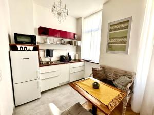 Il comprend une cuisine équipée d'un réfrigérateur blanc et d'une table. dans l'établissement Cozy city Apartment close to metro - Self Check-in, à Vienne