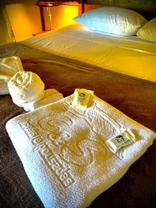 uma cama com um cobertor em cima em Pousada Luar do Rosário em Milho Verde