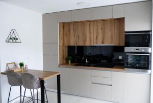 a kitchen with white cabinets and a wooden table at Villa Nana Pag in Pag