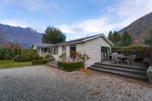 Casa blanca pequeña con mesa y sillas en Frankton Favourite - Queenstown Holiday Home en Queenstown