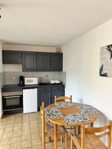 een keuken met een tafel en een tafel en stoelen bij Charmant appartement in Briançon