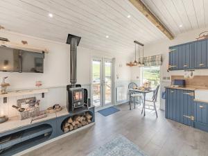 a kitchen with a wood stove and a dining room at The Liddel Dutch Barn - Uk44465 in Saughtree