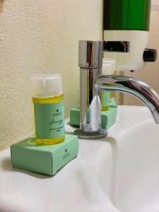 a bathroom sink with a bottle of moisturizing moisturizing soap at Hotel La Capilla - Suites & Apartments San Benito in San Salvador