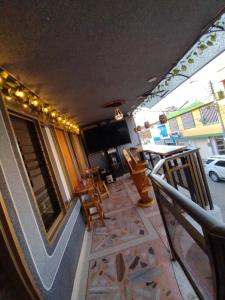 balcón con TV, mesa y sillas en Hotel Casa Aragon, en Cartago