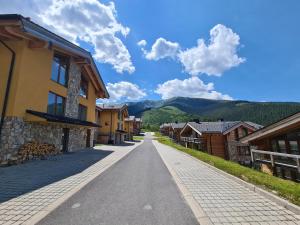 Une rue vide dans un village avec des maisons dans l'établissement SKALA JASNÁ - Free Jacuzzi & Finnish Sauna, à Demänovská Dolina