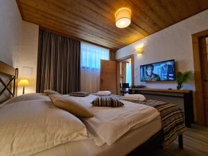 a bedroom with a large bed and a flat screen tv at CHALET ASKALA JASNÁ in Demanovska Dolina