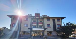 a tall building with the sun shining on it at Verdes Pássaros Apart Hotel in Florianópolis