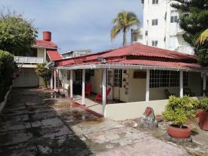 an old white house with a red roof at Aptos Miss Ada in San Andrés