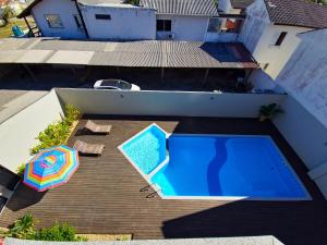 an overhead view of a swimming pool and an umbrella at Verdes Pássaros Apart Hotel in Florianópolis