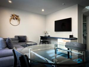 a living room with a couch and a glass table at Beaches Nelson in Nelson