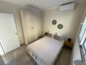 a small bedroom with a white bed and a sink at Villanet SeaView Halkidiki in Mola Kalyva