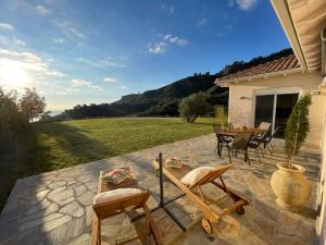 a patio with chairs and a table and a house at Villanet SeaView Halkidiki in Mola Kalyva
