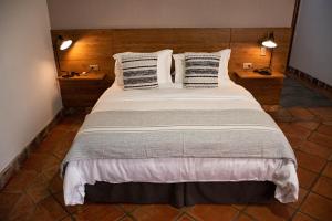 ein großes Bett mit weißer Bettwäsche und Kissen in einem Zimmer in der Unterkunft Valle de Santiago Hotel Boutique in San Cristóbal