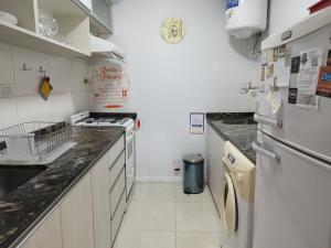a kitchen with white counters and a sink and a refrigerator at CAPi I in Corrientes