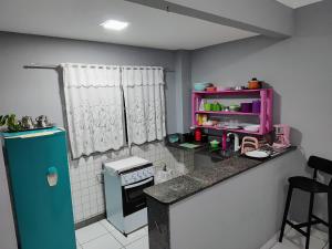 uma pequena cozinha com um frigorífico azul e um balcão em Ed Bertholi - Vista lateral do mar com garagem em Serra