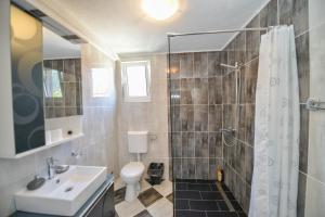 uma casa de banho com um chuveiro, um WC e um lavatório. em J & P Apartments em Kotor