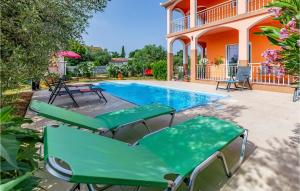 a swimming pool with chairs and a house at 3 Bedroom Amazing Home In Liznjan in Šišan