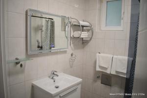 a white bathroom with a sink and a mirror at Draga & Lola in Baška Voda