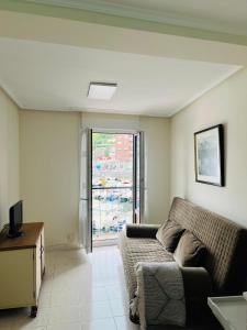 a living room with a couch and a window at Hiruanaiek puerto Bermeo in Bermeo