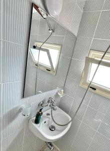 a bathroom with a sink and a shower and a mirror at Hotel Kappa3 Villas in Vlorë