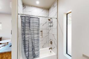 uma casa de banho com um chuveiro e uma banheira branca em Moondance Manor, Unit B em Sedona