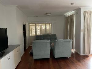 a living room with two chairs and a flat screen tv at D High quality large bed rooms near commercial areas, universities, and rail transit in villas in Melbourne