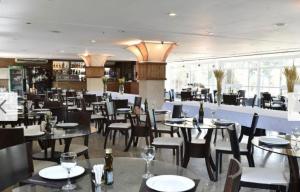 un comedor con mesas y sillas y un restaurante en Gran Lençóis Flat Residen, en Barreirinhas