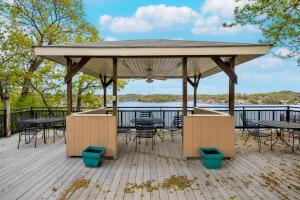 a gazebo with tables and chairs on a deck at On a Point in Lake Ozark