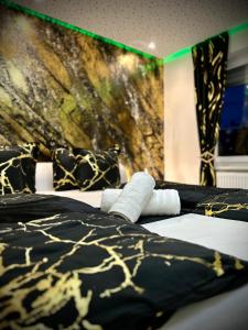 um quarto com 2 camas com cobertores e almofadas preto e dourado em DeLuxe - Apartment ' Andrei 2 ' - Neu in Neuburg an der Donau mit Klimaanlage em Neuburg an der Donau
