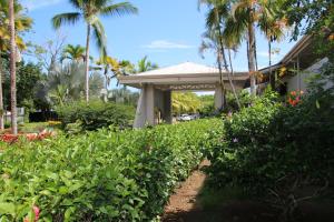 a garden in front of a house with palm trees at Tropical Bliss Pool Wi-Fi BBQ Near Quepos Manuel Antonio in Quepos