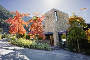 a brick building with autumn trees in front of it at Queenstown Park Boutique Hotel in Queenstown
